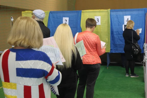 ODESSA, UKRAINE -25.10.2020 - Ukrayna 'da seçimler. COVID-19 Coronavirus salgını sırasında yerel meclis üyelerinin seçim platformu. Oy pusulalarıyla maske ve eldiven takan insanlar