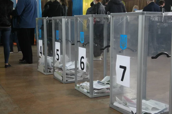 ODESSA, UKRAINE -25.10.2020 - Ukrayna 'da seçimler. COVID-19 Coronavirus salgını sırasında yerel meclis üyelerinin seçim platformu. Oy pusulalarıyla maske ve eldiven takan insanlar