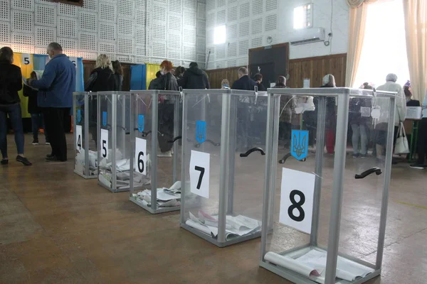 ODESSA, UKRAINE -25.10.2020 - Ukrayna 'da seçimler. COVID-19 Coronavirus salgını sırasında yerel meclis üyelerinin seçim platformu. Oy pusulalarıyla maske ve eldiven takan insanlar