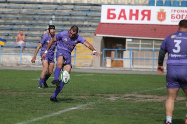 ODESSA, UKRAINE - 20.10.17 - Ukrain Rugby Şampiyonası POLYTECHNIK (Odessa) - siyah. Kamyanets Podolsky - mor. Rugby oyuncularının top için yoğun mücadelesi. Yeşil sahada dinamik bir oyun. Acımasız ragbi