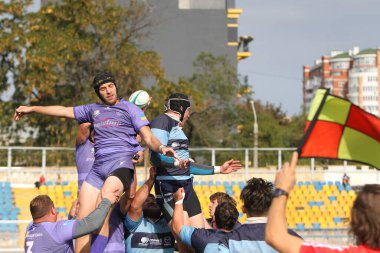 ODESSA, UKRAINE - 20.10.17 - Ukrain Rugby Şampiyonası POLYTECHNIK (Odessa) - siyah. Kamyanets Podolsky - mor. Rugby oyuncularının top için yoğun mücadelesi. Yeşil sahada dinamik bir oyun. Acımasız ragbi