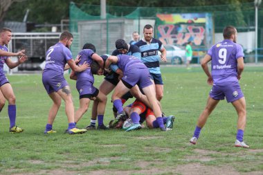 ODESSA, UKRAINE - 20.10.17 - Ukrain Rugby Şampiyonası POLYTECHNIK (Odessa) - siyah. Kamyanets Podolsky - mor. Rugby oyuncularının top için yoğun mücadelesi. Yeşil sahada dinamik bir oyun. Acımasız ragbi