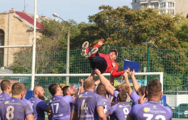 ODESSA, UKRAINE - 20.10.17 - Ukrain Rugby Şampiyonası POLYTECHNIK (Odessa) - siyah. Kamyanets Podolsky - mor. Rugby oyuncularının top için yoğun mücadelesi. Yeşil sahada dinamik bir oyun. Acımasız ragbi