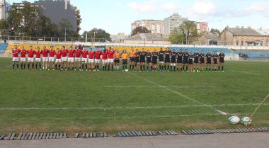 ODESSA, UKRAINE -20.10.17 - Ukrayna ragbi şampiyonası finali CREDO (Odessa) - kırmızı, OLYMPIK (Kharkiv) siyah rugby oyuncularının top için yoğun mücadelesi. Yeşil sahada dinamik bir oyun. Acımasız ragbi