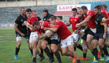 ODESSA, UKRAINE -20.10.17 - Ukrayna ragbi şampiyonası finali CREDO (Odessa) - kırmızı, OLYMPIK (Kharkiv) siyah rugby oyuncularının top için yoğun mücadelesi. Yeşil sahada dinamik bir oyun. Acımasız ragbi