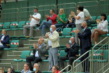 ZAPOROZHYA, UKRAINE - 09 / 20 / 2020 - COVID19 salgını sırasında maskeli seyirciler ve hayranlar kapalı spor salonu stadının tribünlerinde takımlarını destekliyor. COVID salgını sırasında spor hayranları