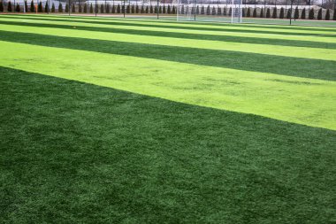 Profesyonel bir futbol sahasında yapay yeşil çimenler. Açık hava suni futbol sahası oyuncuların çıkışını bekliyor