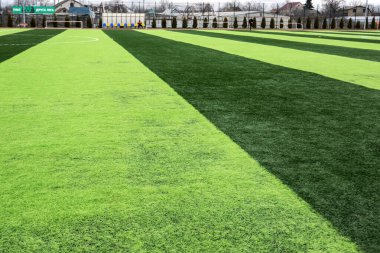 Profesyonel futbol sahasında yapay yeşil çimenler. Oyuncuların çıkışını bekleyen bir suni futbol sahası. Ukraynaca afiş: İkinci profesyonel futbol ligi
