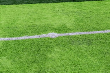 Profesyonel bir futbol sahasında yapay yeşil çimenler. Açık hava suni futbol sahası oyuncuların çıkışını bekliyor