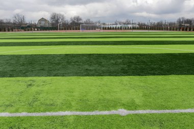 Profesyonel bir futbol sahasında yapay yeşil çimenler. Açık hava suni futbol sahası oyuncuların çıkışını bekliyor