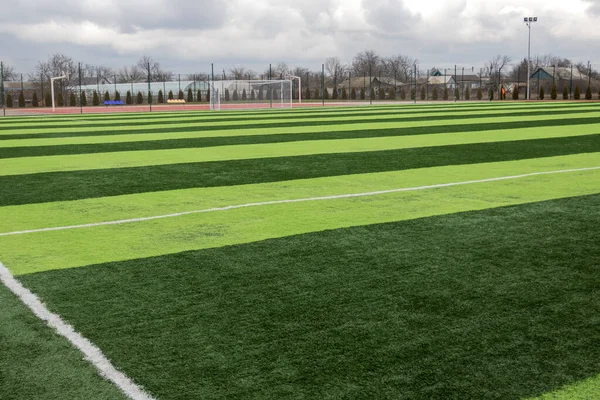 Profesyonel bir futbol sahasında yapay yeşil çimenler. Açık hava suni futbol sahası oyuncuların çıkışını bekliyor