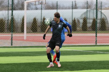 Odessa, Ukrayna - 19 Mart 2021: İkinci lig şampiyonasında yerel amatör futbol takımları stadyumun yapay çimlerinde oynarlar. Futbol sahasında futbol maçları için suni çim.