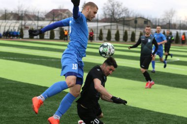 Odessa, Ukrayna - 19 Mart 2021: İkinci lig şampiyonasında yerel amatör futbol takımları stadyumun yapay çimlerinde oynarlar. Futbol sahasında futbol maçları için suni çim.