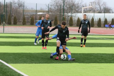 Odessa, Ukrayna - 19 Mart 2021: İkinci lig şampiyonasında yerel amatör futbol takımları stadyumun yapay çimlerinde oynarlar. Futbol sahasında futbol maçları için suni çim.