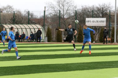 Odessa, Ukrayna - 19 Mart 2021: İkinci lig şampiyonasında yerel amatör futbol takımları stadyumun yapay çimlerinde oynarlar. Futbol sahasında futbol maçları için suni çim.
