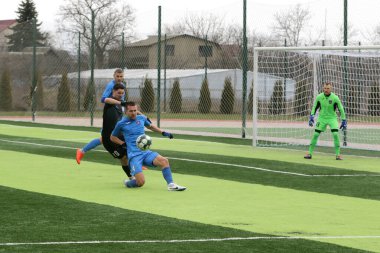 Odessa, Ukrayna - 19 Mart 2021: İkinci lig şampiyonasında yerel amatör futbol takımları stadyumun yapay çimlerinde oynarlar. Futbol sahasında futbol maçları için suni çim.