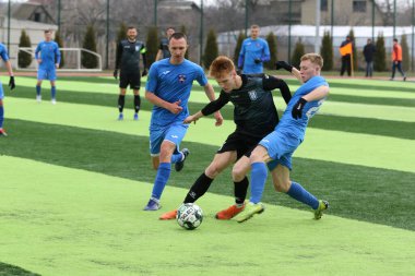 Odessa, Ukrayna - 19 Mart 2021: İkinci lig şampiyonasında yerel amatör futbol takımları stadyumun yapay çimlerinde oynarlar. Futbol sahasında futbol maçları için suni çim.
