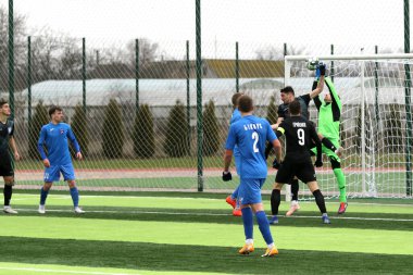 Odessa, Ukrayna - 19 Mart 2021: İkinci lig şampiyonasında yerel amatör futbol takımları stadyumun yapay çimlerinde oynarlar. Futbol sahasında futbol maçları için suni çim.