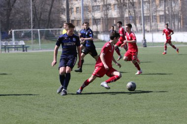Odessa, Ukrayna - 11 Nisan 2021: Yerel çocuk futbol takımları U-17 yapay stadyum çimlerinde oynuyor. Futbol sahasında futbol maçları için yapay çim. Çocuklar futbol oynuyor.