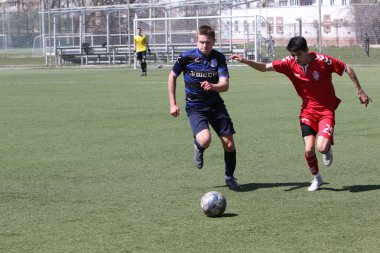 Odessa, Ukrayna - 11 Nisan 2021: Yerel çocuk futbol takımları U-17 yapay stadyum çimlerinde oynuyor. Futbol sahasında futbol maçları için yapay çim. Çocuklar futbol oynuyor.