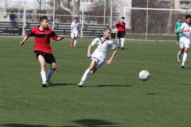 Odessa, Ukrayna - 7 Nisan 2021: Yerel çocuk futbol takımları yapay stadyum çimlerinde oynuyorlar. Futbol sahasında futbol maçları için yapay çim. Çocuklar futbol oynuyor.
