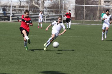 Odessa, Ukrayna - 7 Nisan 2021: Yerel çocuk futbol takımları yapay stadyum çimlerinde oynuyorlar. Futbol sahasında futbol maçları için yapay çim. Çocuklar futbol oynuyor.