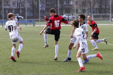 Odessa, Ukrayna - 7 Nisan 2021: Yerel çocuk futbol takımları yapay stadyum çimlerinde oynuyorlar. Futbol sahasında futbol maçları için yapay çim. Çocuklar futbol oynuyor.