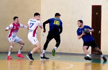 ODESSA, UKRAINE - 23 Nisan 2021: Ukrayna Erkekler Hentbol Federasyonu. Match Odessa - Motor Sich, Zaporozhye - beyaz. Erkekler hentbol maçında aksiyon. Topla sert hücum