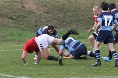 ODESSA, UKRAINE - 17 Nisan 2021: Rugby Kupası 7. Odessa Polytechnic Derby - mavi, CREDO - kırmızı. Erkeklerin ragbi maçının gergin anı. Dramatik ve zorlu erkek ragbi müsabakası. Erkekler ragbi sahasında savaşır