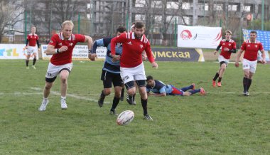 ODESSA, UKRAINE - 17 Nisan 2021: Rugby Kupası 7. Odessa Polytechnic Derby - mavi, CREDO - kırmızı. Erkeklerin ragbi maçının gergin anı. Dramatik ve zorlu erkek ragbi müsabakası. Erkekler ragbi sahasında savaşır