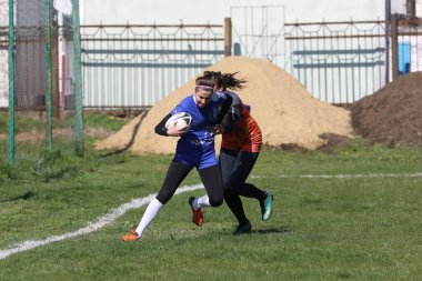 ODESSA, UKRAINE -17 Nisan 2021: 7 bayanlar ragbi takımı arasında Ukrayna Kupası. Odessa - mavi, Kiev Havacılık - turuncu. Kadın ragbi maçının gerginlik anı. Bayanlar ragbi takımı için dramatik meydan okuma oyunu