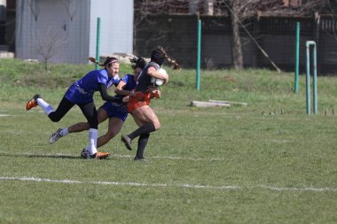 ODESSA, UKRAINE -17 Nisan 2021: 7 bayanlar ragbi takımı arasında Ukrayna Kupası. Odessa - mavi, Kiev Havacılık - turuncu. Kadın ragbi maçının gerginlik anı. Bayanlar ragbi takımı için dramatik meydan okuma oyunu