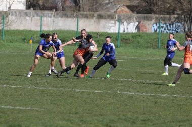 ODESSA, UKRAINE -17 Nisan 2021: 7 bayanlar ragbi takımı arasında Ukrayna Kupası. Odessa - mavi, Kiev Havacılık - turuncu. Kadın ragbi maçının gerginlik anı. Bayanlar ragbi takımı için dramatik meydan okuma oyunu