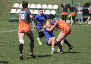 ODESSA, UKRAINE -17 Nisan 2021: 7 bayanlar ragbi takımı arasında Ukrayna Kupası. Odessa - mavi, Kiev Havacılık - turuncu. Kadın ragbi maçının gerginlik anı. Bayanlar ragbi takımı için dramatik meydan okuma oyunu