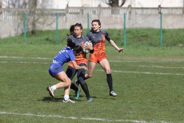 ODESSA, UKRAINE -17 Nisan 2021: 7 bayanlar ragbi takımı arasında Ukrayna Kupası. Odessa - mavi, Kiev Havacılık - turuncu. Kadın ragbi maçının gerginlik anı. Bayanlar ragbi takımı için dramatik meydan okuma oyunu