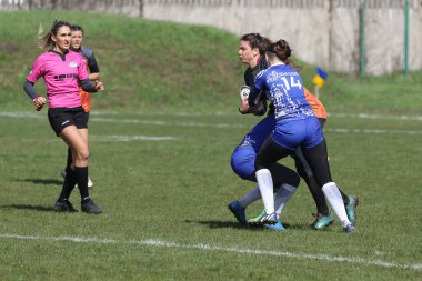 ODESSA, UKRAINE -17 Nisan 2021: 7 bayanlar ragbi takımı arasında Ukrayna Kupası. Odessa - mavi, Kiev Havacılık - turuncu. Kadın ragbi maçının gerginlik anı. Bayanlar ragbi takımı için dramatik meydan okuma oyunu