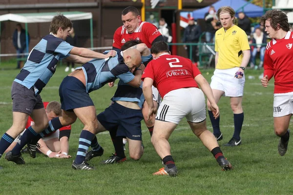 ODESSA, UKRAINE - 17 Nisan 2021: Rugby Kupası 7. Odessa Polytechnic Derby - mavi, CREDO - kırmızı. Erkeklerin ragbi maçının gergin anı. Dramatik ve zorlu erkek ragbi müsabakası. Erkekler ragbi sahasında savaşır