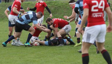 ODESSA, UKRAINE - 17 Nisan 2021: Rugby Kupası 7. Odessa Polytechnic Derby - mavi, CREDO - kırmızı. Erkeklerin ragbi maçının gergin anı. Dramatik ve zorlu erkek ragbi müsabakası. Erkekler ragbi sahasında savaşır