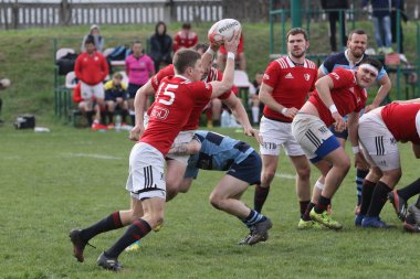 ODESSA, UKRAINE - 17 Nisan 2021: Rugby Kupası 7. Odessa Polytechnic Derby - mavi, CREDO - kırmızı. Erkeklerin ragbi maçının gergin anı. Dramatik ve zorlu erkek ragbi müsabakası. Erkekler ragbi sahasında savaşır