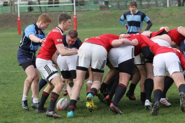 ODESSA, UKRAINE - 17 Nisan 2021: Rugby Kupası 7. Odessa Polytechnic Derby - mavi, CREDO - kırmızı. Erkeklerin ragbi maçının gergin anı. Dramatik ve zorlu erkek ragbi müsabakası. Erkekler ragbi sahasında savaşır