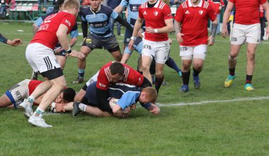 ODESSA, UKRAINE - 17 Nisan 2021: Rugby Kupası 7. Odessa Polytechnic Derby - mavi, CREDO - kırmızı. Erkeklerin ragbi maçının gergin anı. Dramatik ve zorlu erkek ragbi müsabakası. Erkekler ragbi sahasında savaşır