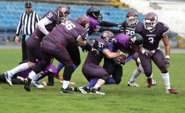 ODESSA, UKRAINE - 30 Mayıs 2021: Zorlu bir düello, Stadyumun ıslak çimlerinde Odessa Reingerlar ve Nikolaev VİKİNGS arasında bir savaş. Sert Amerikan Futbolu Sporcuları Savaşı