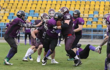 ODESSA, UKRAINE - 30 Mayıs 2021: Zorlu bir düello, Stadyumun ıslak çimlerinde Odessa Reingerlar ve Nikolaev VİKİNGS arasında bir savaş. Sert Amerikan Futbolu Sporcuları Savaşı