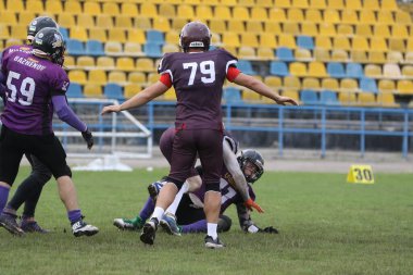 ODESSA, UKRAINE - 30 Mayıs 2021: Zorlu bir düello, Stadyumun ıslak çimlerinde Odessa Reingerlar ve Nikolaev VİKİNGS arasında bir savaş. Sert Amerikan Futbolu Sporcuları Savaşı