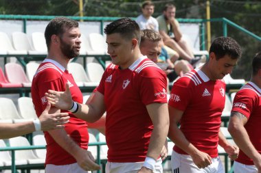 Odessa, Ukrayna - 23 Haziran 2021: Odessa Milli Takımı CREDO (kırmızı) - OLYMP-Kharkiv (sarı) in rugby 7s. Top için erkek rugby oyuncularının sert agresif dövüşü. Stadyumun yeşil çimlerinde dinamik bir oyun