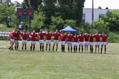 Odessa, Ukrayna - 23 Haziran 2021: Odessa Milli Takımı CREDO (kırmızı) - OLYMP-Kharkiv (sarı) in rugby 7s. Top için erkek rugby oyuncularının sert agresif dövüşü. Stadyumun yeşil çimlerinde dinamik bir oyun