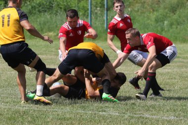 Odessa, Ukrayna - 23 Haziran 2021: Odessa Milli Takımı CREDO (kırmızı) - OLYMP-Kharkiv (sarı) in rugby 7s. Top için erkek rugby oyuncularının sert agresif dövüşü. Stadyumun yeşil çimlerinde dinamik bir oyun