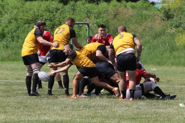 Odessa, Ukrayna - 23 Haziran 2021: Odessa Milli Takımı CREDO (kırmızı) - OLYMP-Kharkiv (sarı) in rugby 7s. Top için erkek rugby oyuncularının sert agresif dövüşü. Stadyumun yeşil çimlerinde dinamik bir oyun