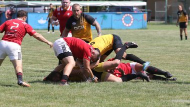 Odessa, Ukrayna - 23 Haziran 2021: Odessa Milli Takımı CREDO (kırmızı) - OLYMP-Kharkiv (sarı) in rugby 7s. Top için erkek rugby oyuncularının sert agresif dövüşü. Stadyumun yeşil çimlerinde dinamik bir oyun