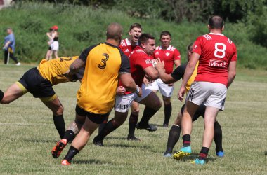 Odessa, Ukrayna - 23 Haziran 2021: Odessa Milli Takımı CREDO (kırmızı) - OLYMP-Kharkiv (sarı) in rugby 7s. Top için erkek rugby oyuncularının sert agresif dövüşü. Stadyumun yeşil çimlerinde dinamik bir oyun